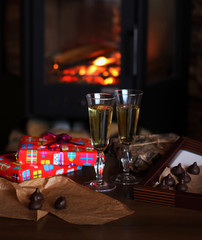 Glasses of drink are on the table by the fireplace