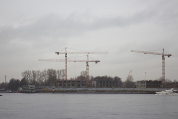 tower cranes on the shore on a cloudy day