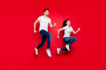 Turned photo of cheerful positive nice pretty cute couple boyfriend girlfriend wearing jeans denim white t-shirt smiling toothy footwear urgent for sales isolated over vivid color background