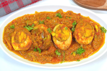 Spicy egg curry dish garnished with coriander leaves