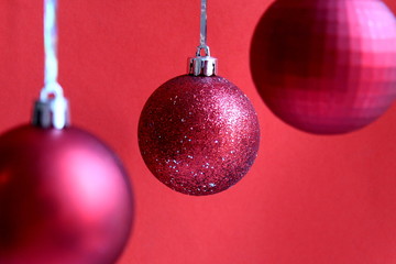 red christmas balls hanging on a red background