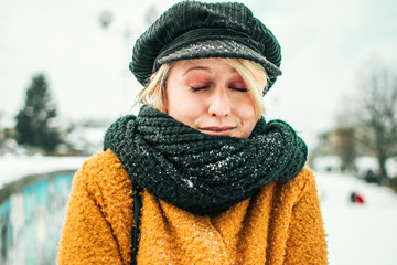 Portrait of cute blond girl in winter clothing, freezing outside. Winter time