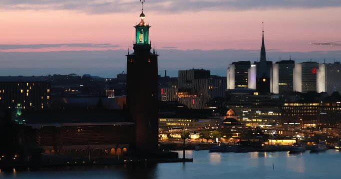 Stockholm, Sweden. Scenic Skyline View Of Famous Tower Of Stockholm City Hall. Building Of Municipal Council. Famous Popular Destination Place In Dusk Lights. Night Lighting. 4K
