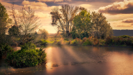 Obraz premium light rays sunset lake