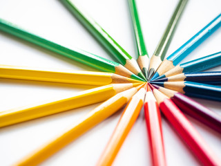 Many different colored pencils on white background, Colored pencils in arrange in color wheel colors on white background, Group of multicolor pencils.