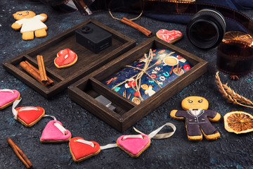 Wooden photo box with photo for Valentine's Day or Wedding Day. Decorated with gingerbreads. Romantic or love concept. Gingerbreads for Valentines Day on dark concrete background