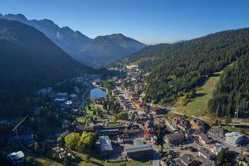 Fototapeta na wymiar Aerial view of ski resort Madonna di Campiglio, italy. Morning is the autumn season. In the background a clear blue sky
