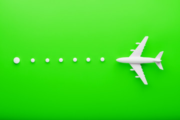 White passenger plane with trajectory points as on a route map, isolated with a bright green background.