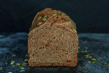 Fresh homemade rectangular bread on a dark background. Mother dough bread. Homemade bread sourdough, rustic baked bread. minimalism