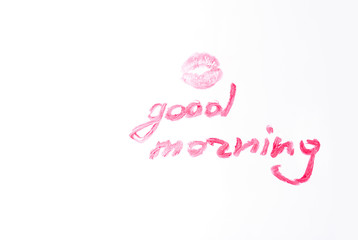 the imprint of a kiss with bright lipstick and lipstick inscription good morning on a white background