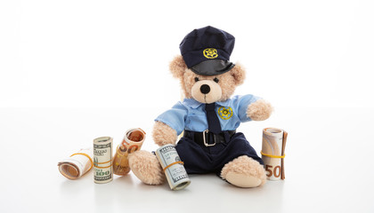 Teddy in policeman uniform holding banknotes isolated against white background