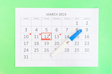 Positive pregnancy test with circling date in calendar. Planning of pregnancy, trying to have baby.