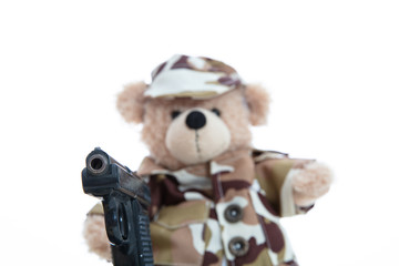 Cute teddy bear in soldier uniform with a handgun isolated against white background