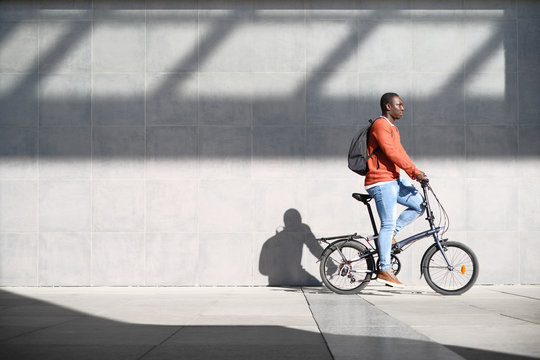 African Man Riding Folding Bike For Urban Commuting