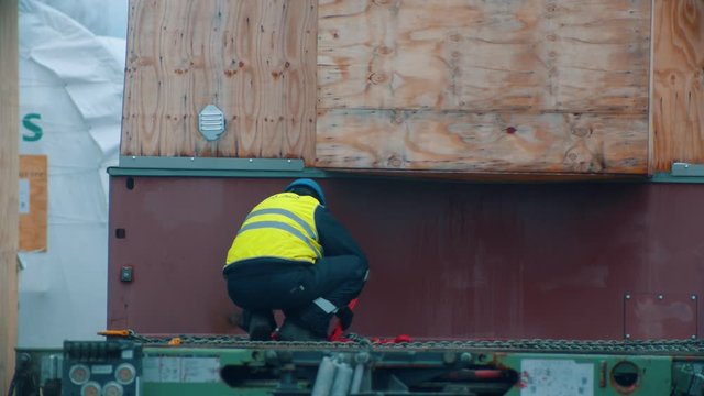 Cargo shipping - men working on the construction site - unhook the cargo from the truck