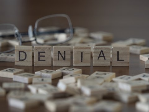 The concept of Denial represented by wooden letter tiles