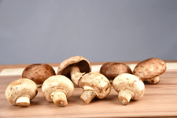 Fresh champignon mushrooms on wooden table, closeup. Space for text