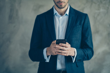 Cropped photo of focused agent using his smartphone have online chatting with his clients colleagues wear modern outfit isolated over grey color background