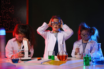 Children doing chemical research in laboratory. Dangerous experiment