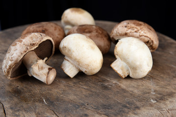 Fresh champignon mushrooms on wooden table, closeup. Space for text