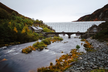 Autumn scene of water flowing over the Caban Coch Dam in Elan Valley