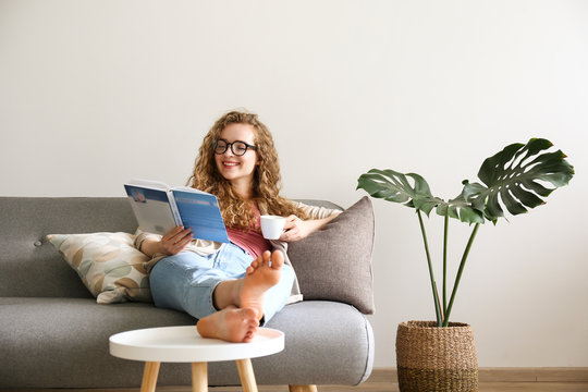 Curly haired brunette woman relaxing on the couch at home.