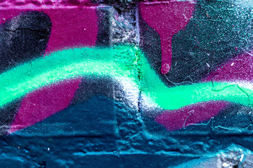 Fragment of colored graffiti painted on a brick wall. © Eugene_Photo