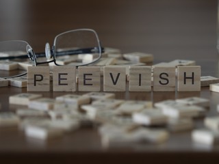 The concept of Peevish represented by wooden letter tiles