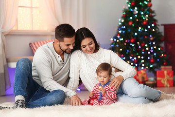 Fototapeta premium Happy family with cute baby at home. Christmas celebration
