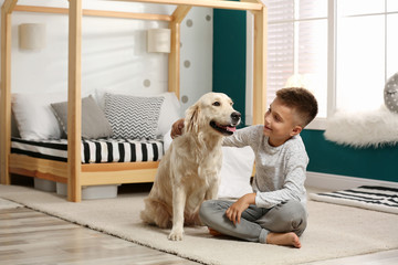 Little boy with his dog in stylish bedroom interior