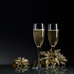 Two glasses of champagne ready to bring New Year on a black background.