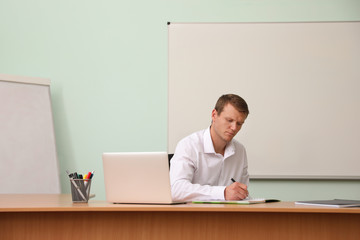 Male teacher at his desk in classroom