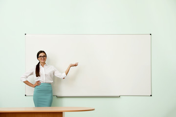Female teacher near whiteboard in modern classroom