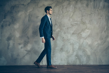 Full length body size side profile photo of serious confident man walking forward in shoes with stubble isolated grey color background