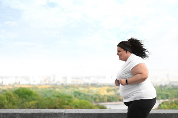 Beautiful overweight woman running outdoors. Fitness lifestyle