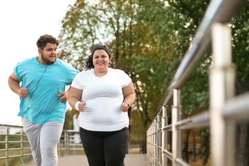 Overweight couple running together in park