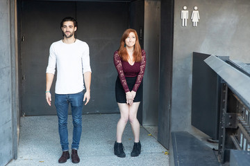 Man and woman waiting to use the bathroom