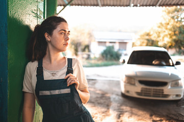 The concept of women's equality and feminism. A woman in a work uniform stands against the wall,...