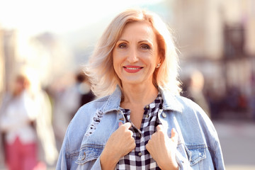 Portrait of happy mature woman on city street