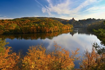 Beautiful autumn landscape with old castle Veveri at sunset and beautiful blue sky with clouds. Colorful nature background on autumn season. Brno - Czech Republic.