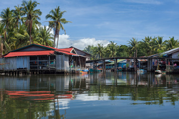 Fototapeta na wymiar Riverside houses in the fishing village of Prek Svay, Koh Rong island, Cambodia, south east Asia, on a calm sunny day.