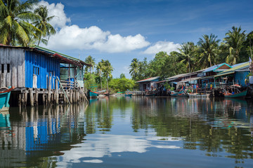Fototapeta na wymiar Riverside houses on stilts in the fishing village of Prek Svay, Koh Rong island, Cambodia, south east Asia, on a calm sunny day.