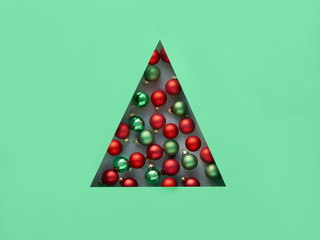 Geometric creative Christmas flat lay in neo mint and red colors. Xmas baubles in triangular paper...