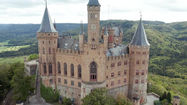 Aerial panorama of Burg Hohenzollern (Hohenzollern castle) with hills and villages surrounded by forests with beautiful foliage