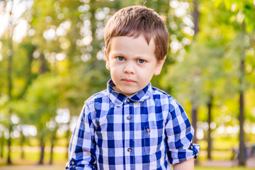 Portrait of a boy in a shirt on the street. Beautiful boy. Little boy. Walk. A child's smile.