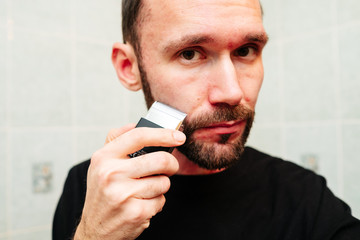 Man snarling at razor with shaving cream and towel