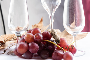 Uvas rojas en decoración con copas vacías