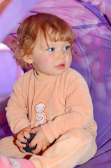 pretty little girl in pajamas playing in her tent
