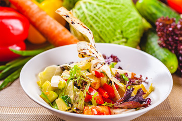 Fattoush salad with different vegetables on white plate