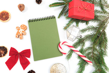 Top view of blank notebook on white background with xmas decorations. Mockup Christmas background with notebook for wish list or to do list. Flat lay with copy space.- Image